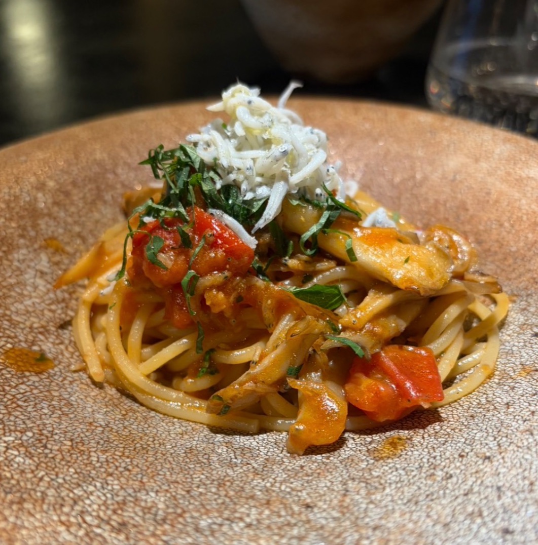 斑点模様のベージュの皿に盛り付けたトマトソースのパスタ